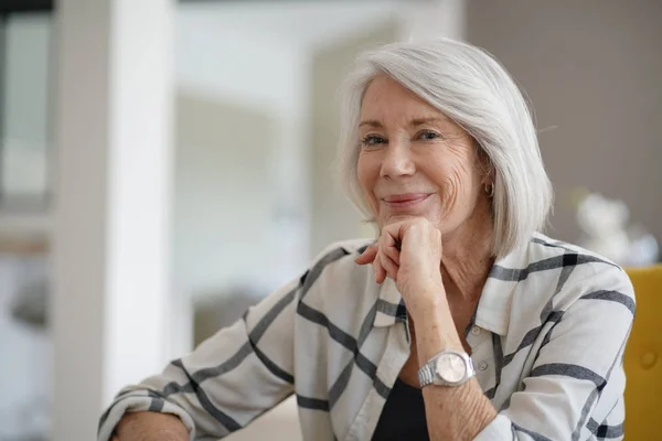 Eleganta Senior Kvinna Sitter Nonchalant Inomhus Och Leende — Stockfoto