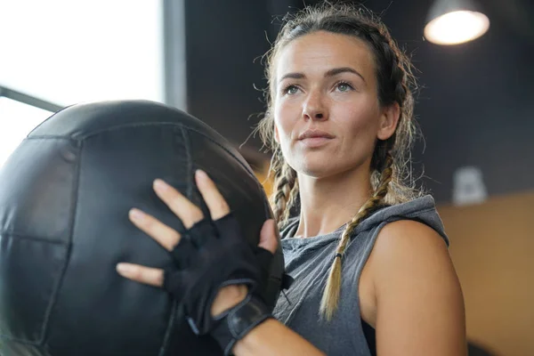 Woman in a gym with a medicine ball