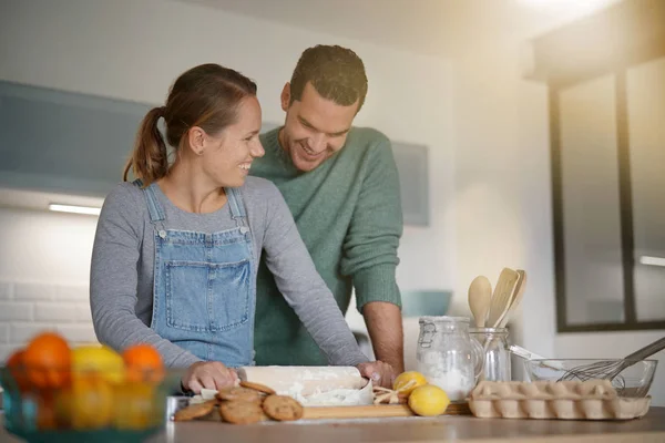 Happy young couple baking together at home
