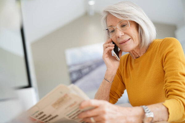 Modern senior woman on cellphone at home                               