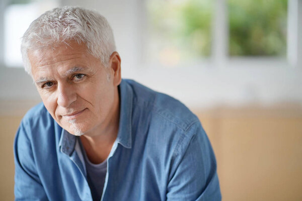 Portrait of senior man with white hair looking at camera