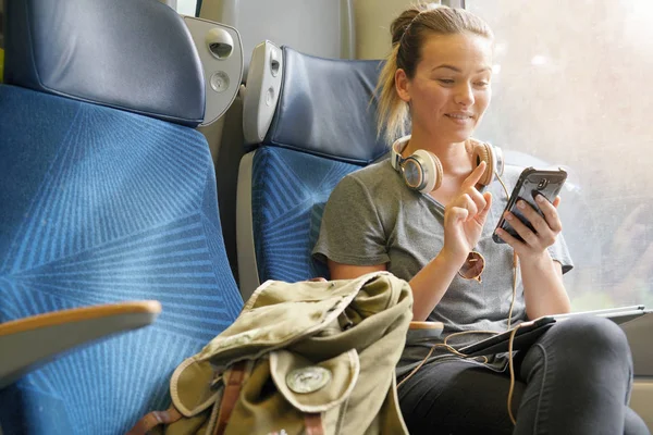 Casual Jonge Vrouw Kijken Naar Haar Mobiel Een Trein — Stockfoto