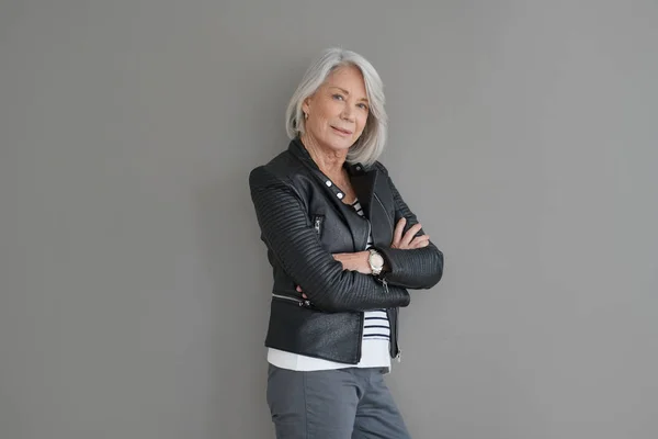 孤立した灰色の背景にレザー ジャケットの現代のシニア女性 — ストック写真