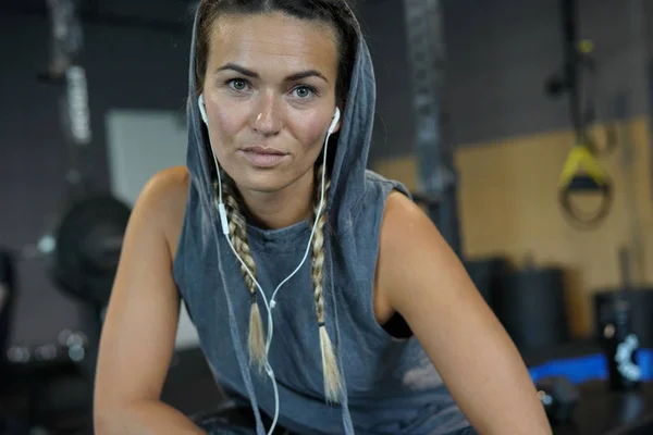 Woman in a gym resting between workouts