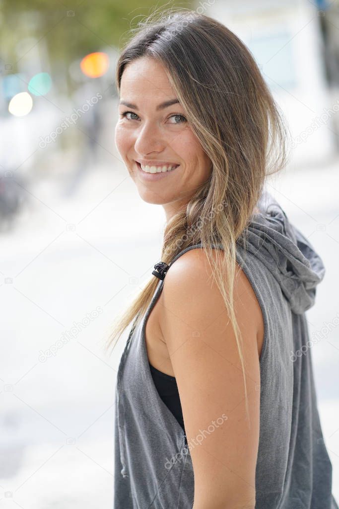  Woman in urbanwear turning around and smiling at the camera                              