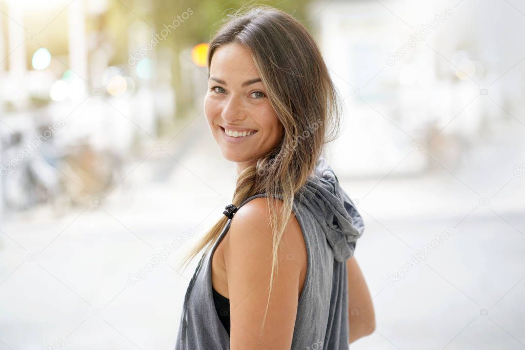  Woman in urbanwear turning around and smiling at the camera                              