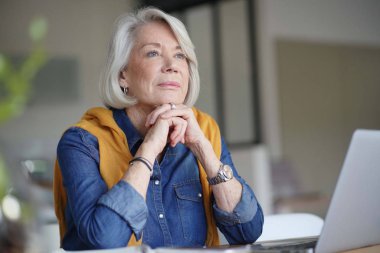  Evde laptop ile dalgın bakıyor güzel kadın kıdemli                              