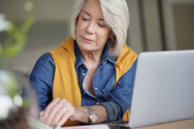 Evde günlük kontrol ve çalışma Modern kadın kıdemli                               