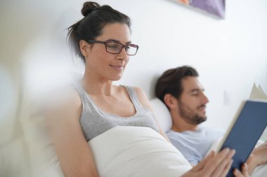 Çekici çift okuma ve yatakta rahatlatıcı