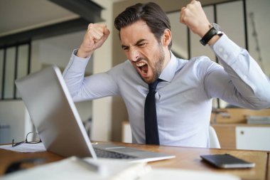Sabır kaybetme ve modern ofis içinde laptop çığlık öfkeli işadamı