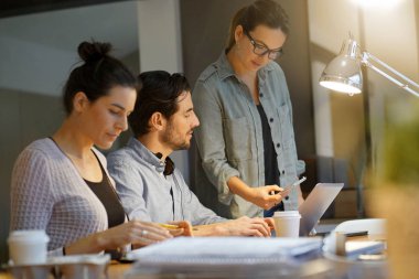 Çalışma arkadaşlarıyla birlikte çalışma alanındaki projeyi gözden geçiriyorlar