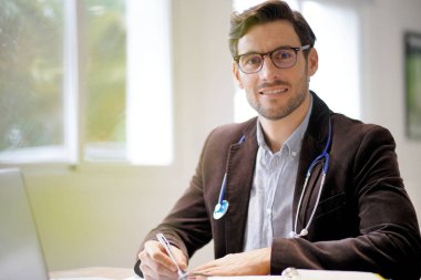  Gülümseyen yakışıklı Doktor office çalışma                            