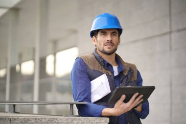 Kask açık havada tablet ve planı ile yakışıklı bina uzman