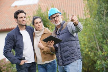  Builder going through outdoor plans with homeowners                                clipart