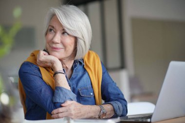  Evde laptop ile dalgın bakıyor güzel kadın kıdemli                              