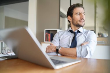 Modern ofisinde çalışan rahat çekici işadamı