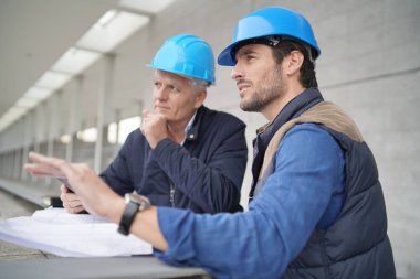 İşçiler modern yapı görüşü üzerine planlar üzerinde danışmanlık yapıyorlar
