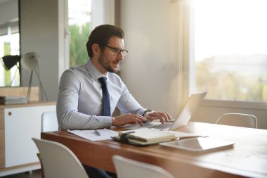 Modern ofis dizüstü bilgisayarda yazarak çekici iş adamı