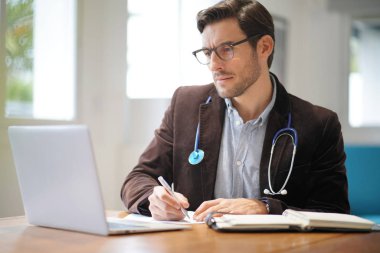  Gülümseyen yakışıklı Doktor office çalışma                            