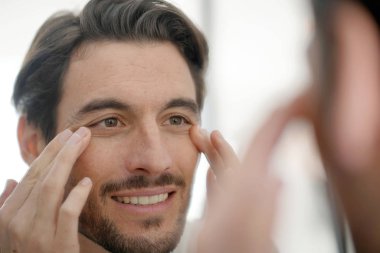 Yakışıklı adam kırışıklıkları aynadaki evde kontrol