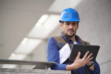 Kask açık havada tablet ve planı ile yakışıklı bina uzman