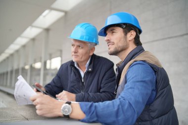 İşçiler modern yapı görüşü üzerine planlar üzerinde danışmanlık yapıyorlar