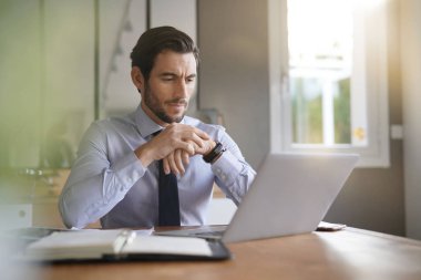 Yakışıklı işadamı modern ofis içinde laptop üzerinde çalışıyor 