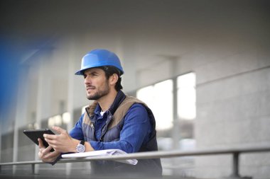 Kask açık havada tablet ve planı ile yakışıklı bina uzman