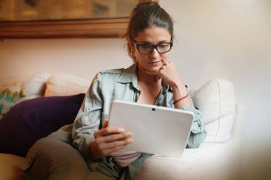 Tablet ile evde kanepede rahat çekici kadın