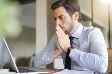 Ofis içinde laptop bakarak yakışıklı iş adamı vurguladı