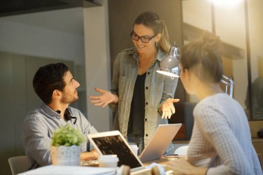 Çalışma arkadaşlarıyla birlikte çalışma alanındaki projeyi gözden geçiriyorlar