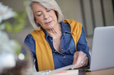 Evde günlük kontrol ve çalışma Modern kadın kıdemli                               