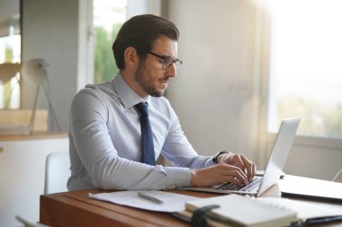 Modern ofis dizüstü bilgisayarda yazarak çekici iş adamı