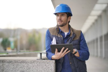 Kask açık havada tablet ve planı ile yakışıklı bina uzman