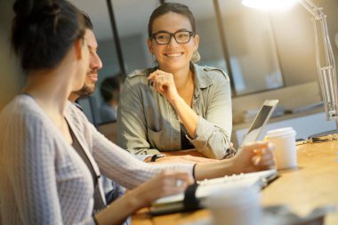 İş arkadaşları ortak çalışma alanında fikirleri tartışıyor