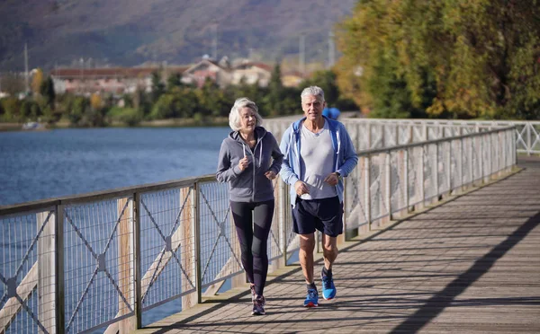 Active Senior Couple Jogging Together Bridge — Stock Photo, Image