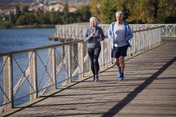 Aktivní Senior Pár Společně Zaběhat Mostě — Stock fotografie