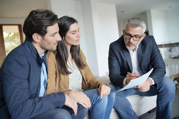 Casal Com Agente Imobiliário Olhando Contrato Casa Moderna — Fotografia de Stock