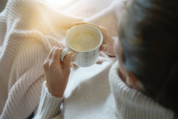 Cosy brunette at home on couch with hot drink