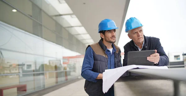 Obreros Sombreros Duros Consultando Sobre Plano Vista Edificio Moderno — Foto de Stock