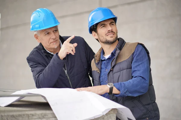 Workman Wskazując Pokazując Coś Pracownika Nowoczesnym Budynku Wzroku — Zdjęcie stockowe
