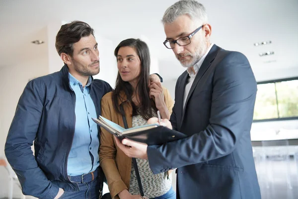 Pareja Con Agente Inmobiliario Visitando Casa Moderna — Foto de Stock