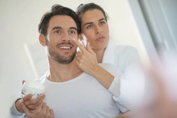 Impressionante Morena Aplicando Creme Facial Seu Parceiro Bonito — Fotografia de Stock