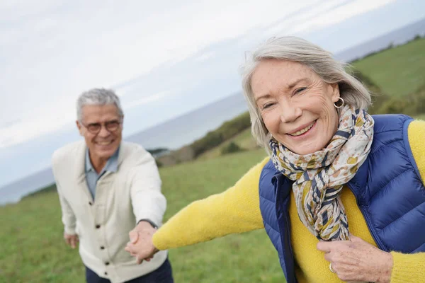 Healthy Senior Woman Holding Husband Hand Leading Way Countryside Walk — Stock Photo, Image