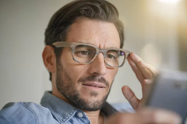 Ellenőrzése Mobiltelefon Design Szemüveget Visel Alkalmi Jóképű Férfi Portréja — Stock Fotó