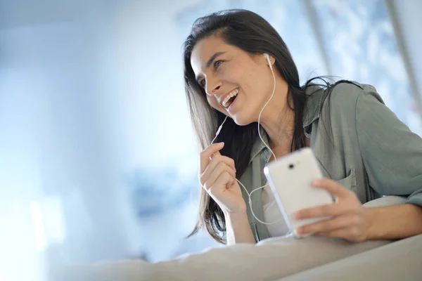 Vacker Brunett Talar Mobiltelefon Med Hörlurar Hemma — Stockfoto