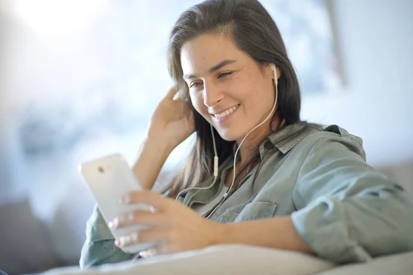 Vacker Brunett Talar Mobiltelefon Med Hörlurar Hemma — Stockfoto