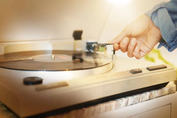 Woman\'s hand on vinyl record player
