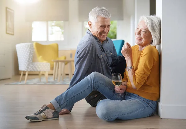 Ontspannen Senior Paar Zittend Vloer Modern Huis Met Glas Wijn — Stockfoto