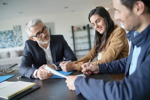 Atractiva Pareja Firmando Contrato Con Agente Inmobiliario Casa Contemporánea —  Fotos de Stock